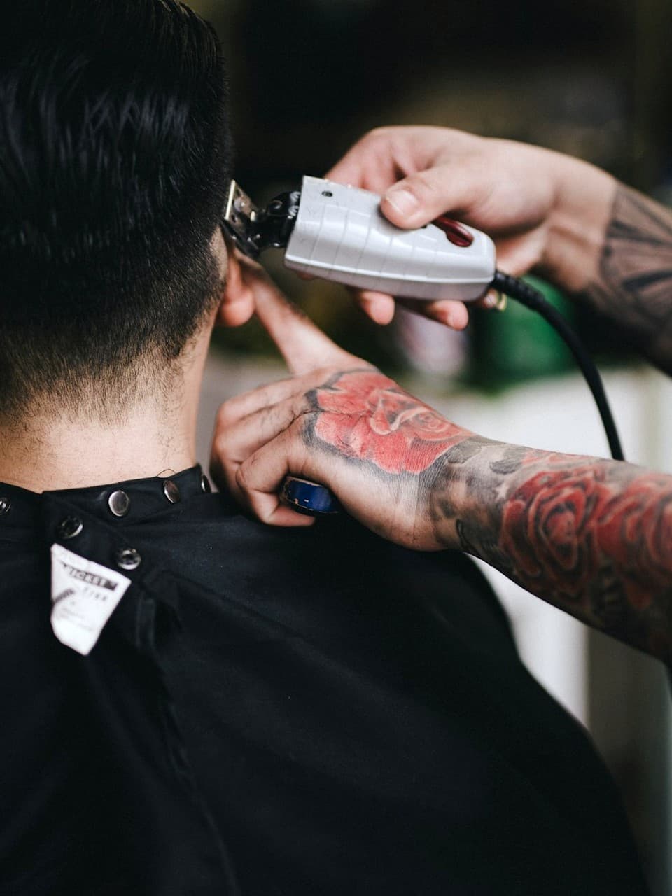 Barber refining a client fade with clippers